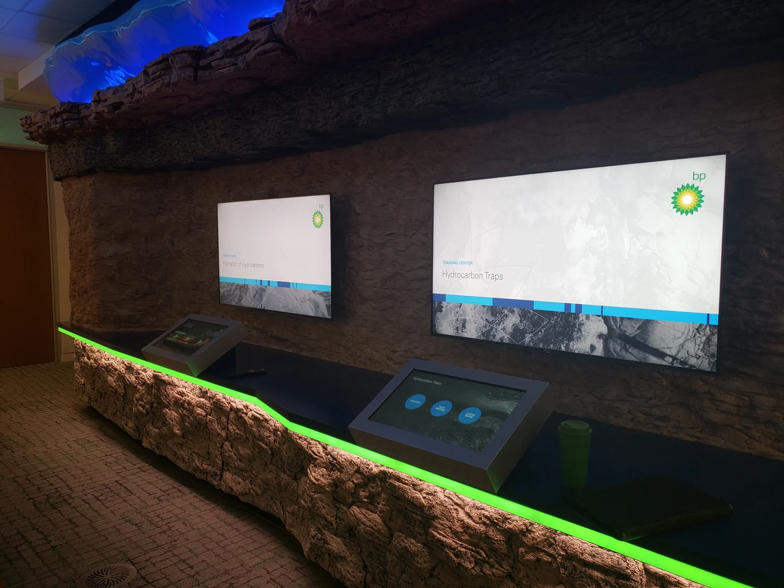 Interactive displays set into a sculpted rock wall at BP's Houston learning center